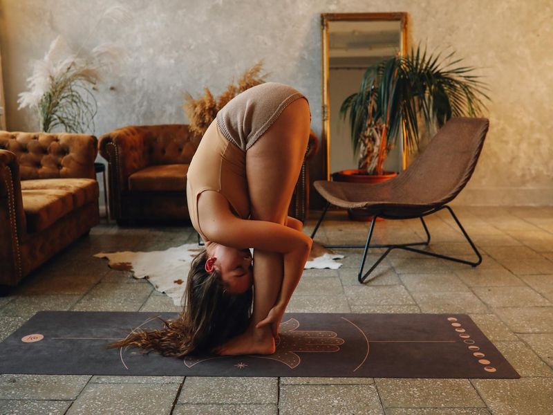 Person stretching on a mat in a calm, modern environment.